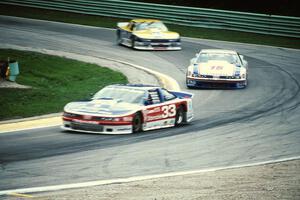 Scott Sharp's Olds Cutlass Supreme, Irv Hoerr's Olds Cutlass Supreme and Chris Kneifel's Chevy Beretta on lap two