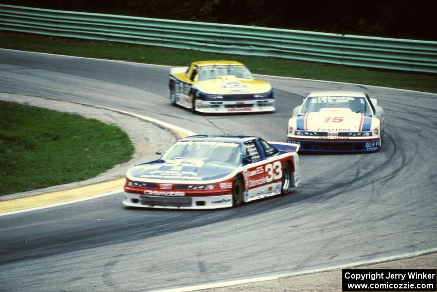 Scott Sharp's Olds Cutlass Supreme, Irv Hoerr's Olds Cutlass Supreme and Chris Kneifel's Chevy Beretta on lap one