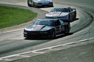 Darin Brassfield's and Chris Kneifel's Olds Cutlass Supremes ahead of Bob Sobey's Chevy Camaro