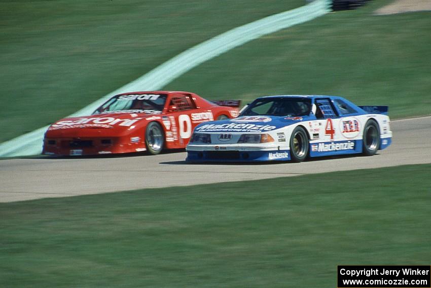 Ron Fellows' Ford Mustang passes John Anderson's Chevy Camaro headed uphill toward turn 6