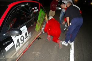 Roman Pakos / Maciej Sawicki change a flat after SS8 in their Ford Focus SVT.(1)