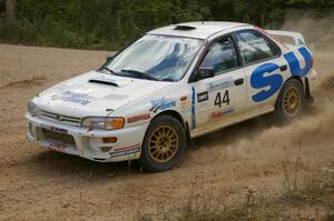 Henry Krolikowski / Cindy Krolikowski drift through a fast sweeper on SS10 in their Subaru Impreza.