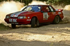 Mark Utecht / Rob Bohn spray gravel as they accelerate out of a 90-right on SS12 in their Ford Mustang.