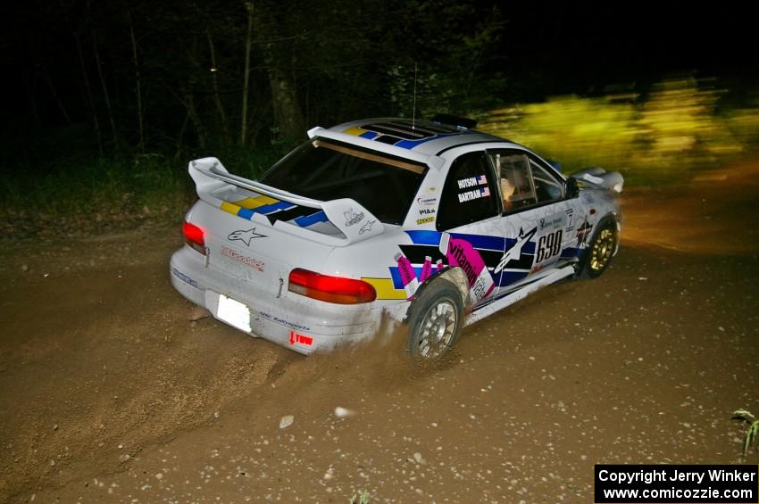 Kenny Bartram / Dennis Hotson drift through a fast downhill left-hander on SS5 in their Subaru Impreza.