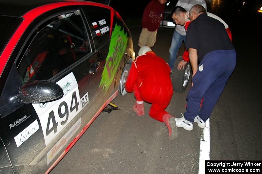 Roman Pakos / Maciej Sawicki change a flat after SS8 in their Ford Focus SVT.(1)