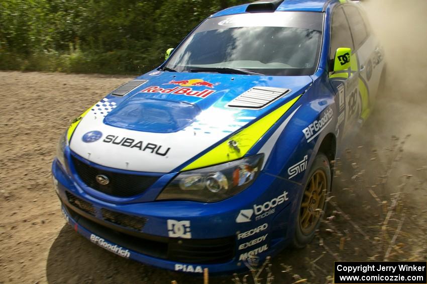 Travis Pastrana / Derek Ringer drifting rapidly past the apex of a corner on SS10 in their Subaru WRX STi.