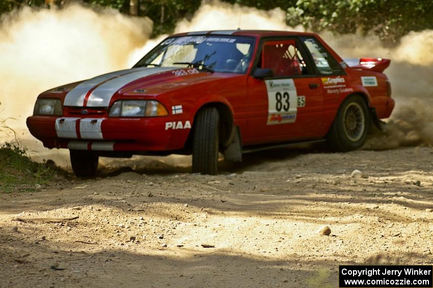 Mark Utecht / Rob Bohn spray gravel as they accelerate out of a 90-right on SS12 in their Ford Mustang.