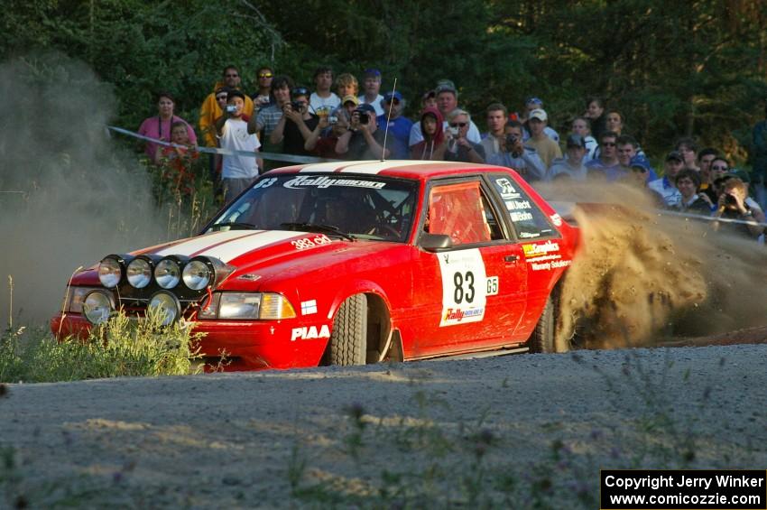 Mark Utecht / Rob Bohn spray gravel as they drive past spectators on SS13 in their Ford Mustang.