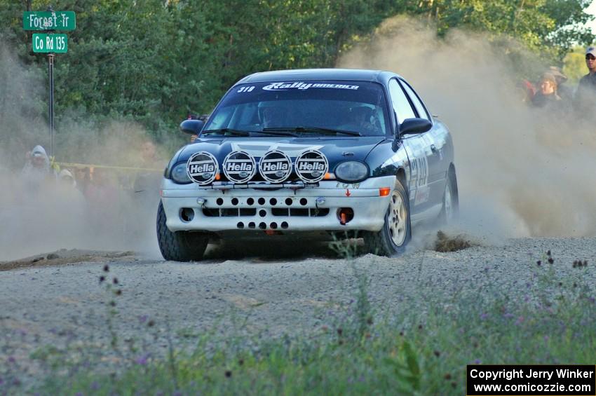 Chris Greenhouse / Don DeRose sling gravel as they enter onto the county road spectator point on SS13 in their Plymouth Neon.