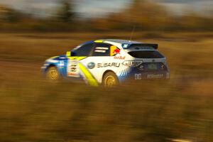 Ken Block / Alex Gelsomino at speed down a straight on the practice stage in their Subaru WRX STi.