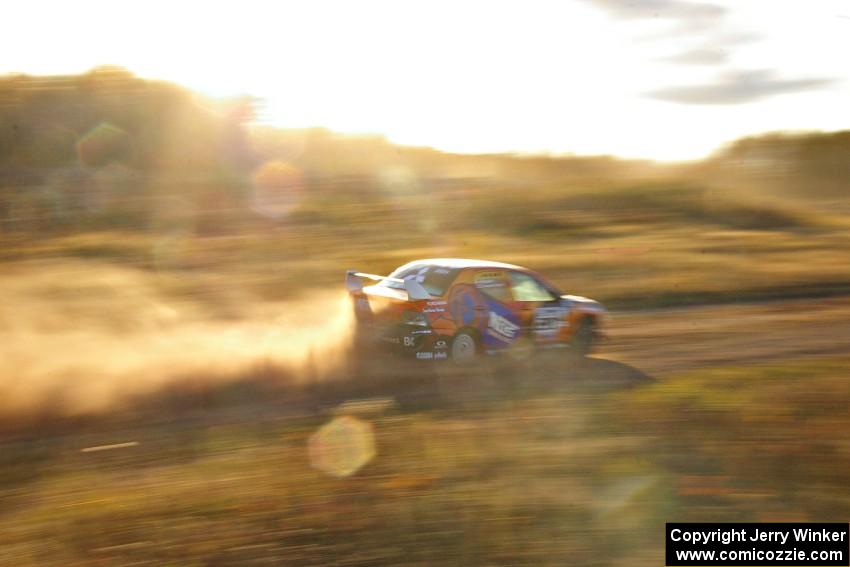 The Andrew Comrie-Picard / Marc Goldfarb Mitsubishi Lancer Evo 9 RS at speed down a straight on the practice stage.