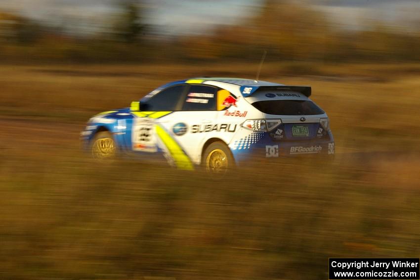 Ken Block / Alex Gelsomino at speed down a straight on the practice stage in their Subaru WRX STi.