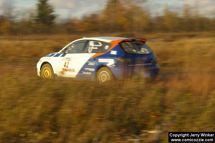 Eric Burmeister / Dave Shindle at speed down a straight on the practice stage in their Mazda Speed 3.