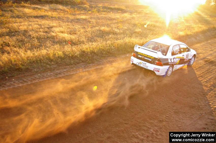 The Andi Mancin / Maciej Wislawski Mitsubishi Evo 9 flies down a straight on the practice stage.