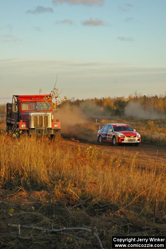 Arkadiusz Gruszka / Michal Chodan blast past a gravel truck stationed on the outside of a sweeper on the practice stage in their