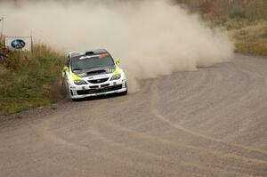 Ken Block / Alex Gelsomino take a wide line into a 90-left on SS1 in their Subaru WRX STi.