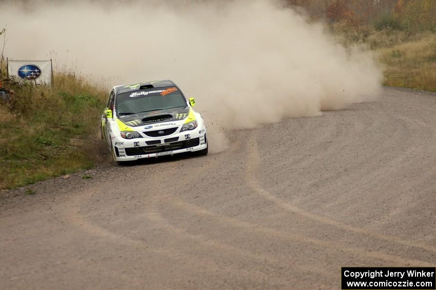 Ken Block / Alex Gelsomino take a wide line into a 90-left on SS1 in their Subaru WRX STi.