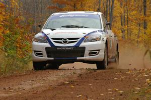Eric Burmeister / Dave Shindle cruise over a small crest near the finish of SS10, Gratiot Lake 1, in their Mazda Speed 3.