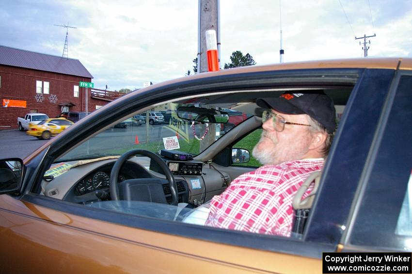 Charlie Cotterman listens to the net at Kenton service as Kyle Sarasin / Mikael Johansson leave in their Subaru Impreza.