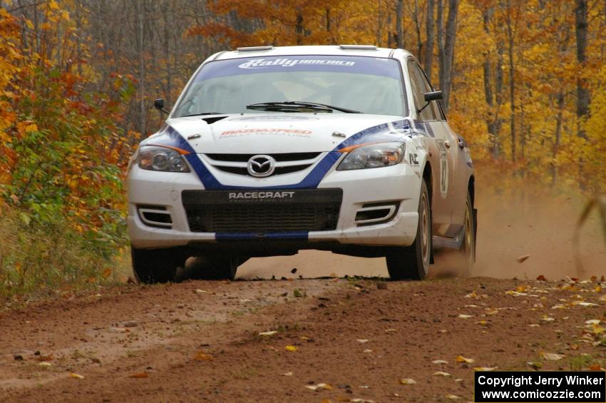 Eric Burmeister / Dave Shindle cruise over a small crest near the finish of SS10, Gratiot Lake 1, in their Mazda Speed 3.