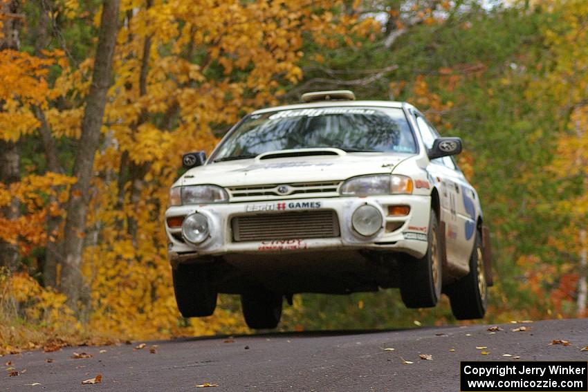 Henry Krolikowski / Cindy Krolikowski prepare for liftoff at the midpoint jump on Brockway 2, SS14, in their Subaru Impreza.