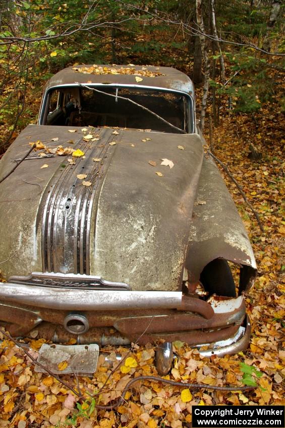 A mid-fifties Pontiac rusts away in the fall forest near the Michigan/Wisconsin border.