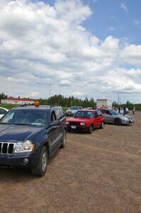 Workers line up their cars to head out into the woods.