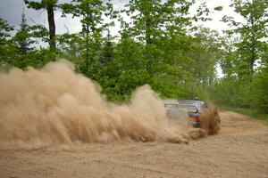 Janusz Topor / Michal Kaminski drift their Subaru Impreza through a dusty hard left on SS1.