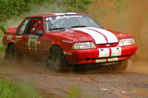 Mark Utecht / Rob Bohn drift their Ford Mustang through a large puddle on SS5.