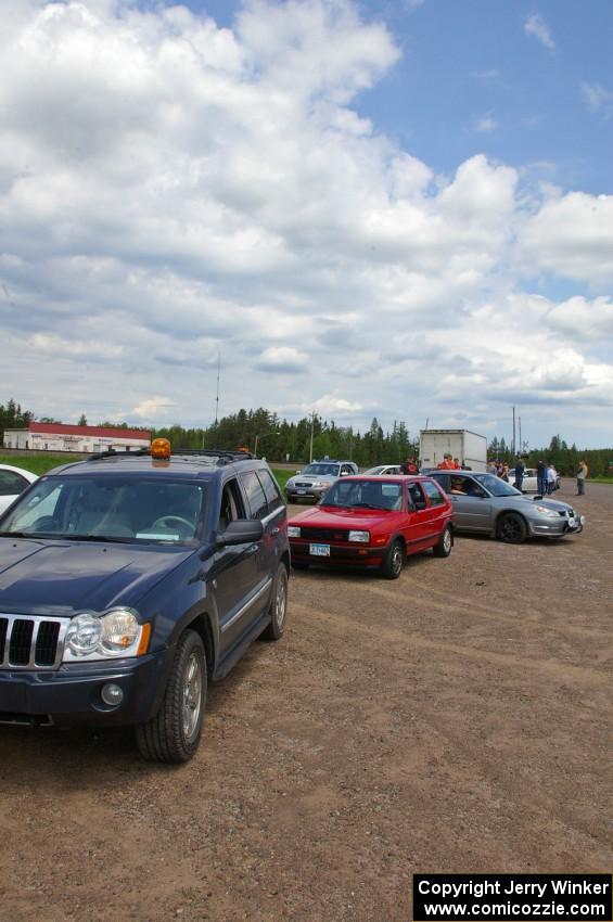 Workers line up their cars to head out into the woods.