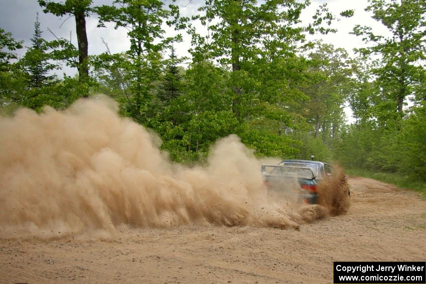 Janusz Topor / Michal Kaminski drift their Subaru Impreza through a dusty hard left on SS1.