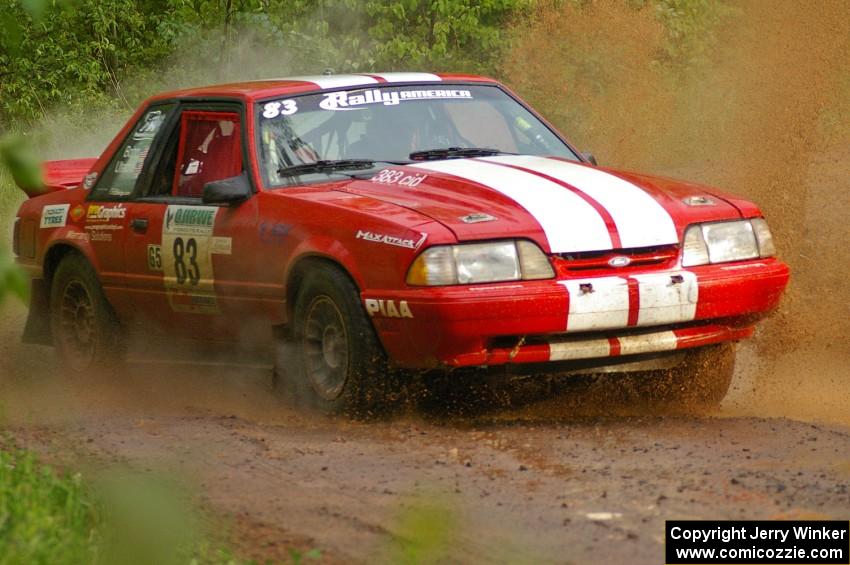 Mark Utecht / Rob Bohn drift their Ford Mustang through a large puddle on SS5.