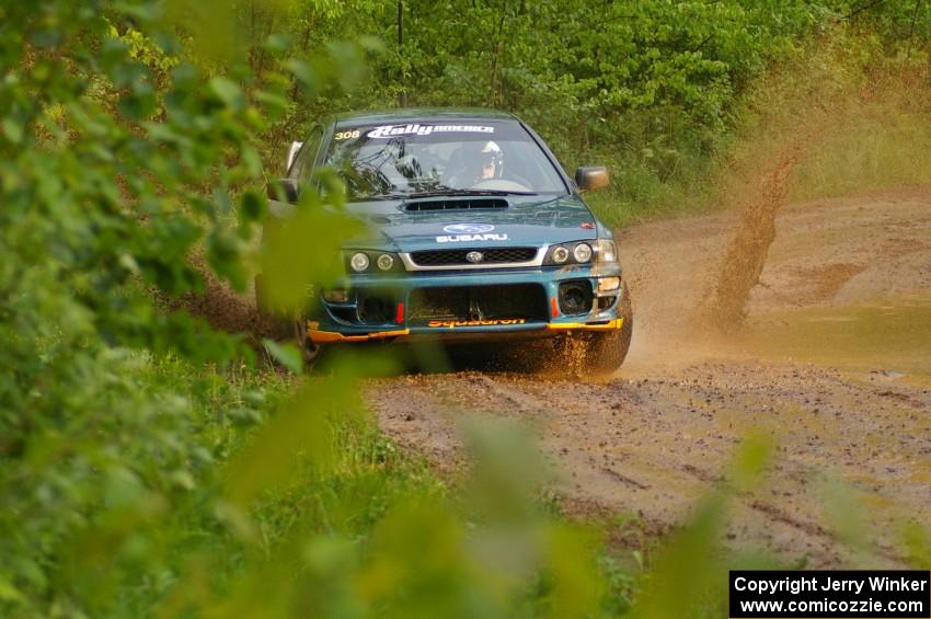 The Janusz Topor / Michal Kaminski Subaru Impreza hits a large puddle on SS5.