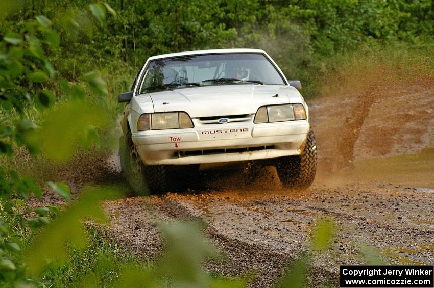 The Bonnie Stoehr / Jake Weber Ford Mustang hits a large puddle on SS5.