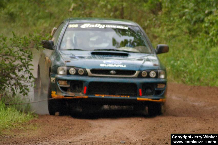 Janusz Topor / Michal Kaminski drift their Subaru Impreza through a right-sweeper just after hitting a large puddle on SS6.