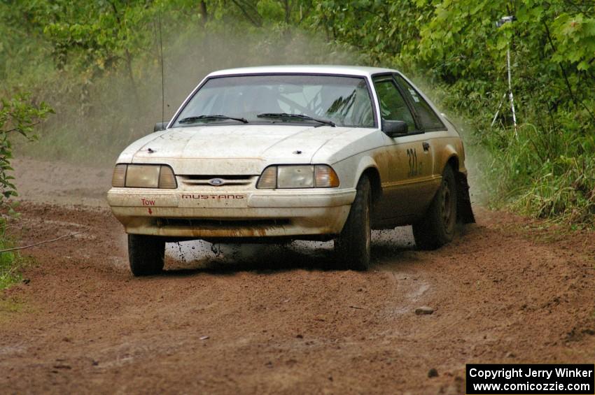 Steam billows off the hot exhaust of the Bonnie Stoehr / Jake Weber Ford Mustang after hitting a large puddle on SS6.