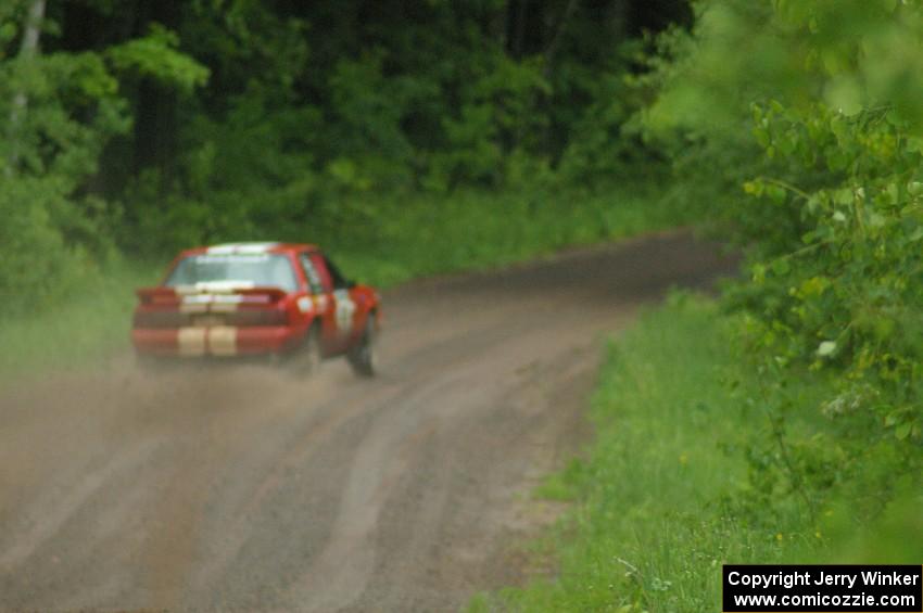 Mark Utecht / Rob Bohn set up their Ford Mustang for a sweeper on SS3 during a heavy rainfall.