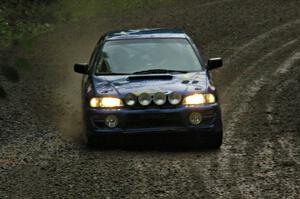 Kazimierz Pudelek / Michal Nawracaj drift their Subaru Impreza through a downhill sweeper on SS5 in the pouring rain.