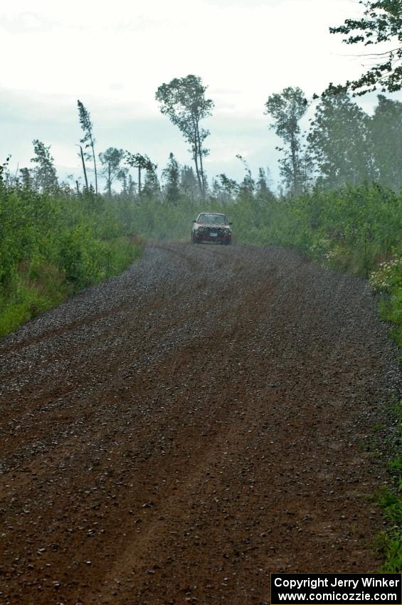 John Kimmes / Greg Smith drive their VW GTI down a straight on SS3 in the absolute pouring rain.