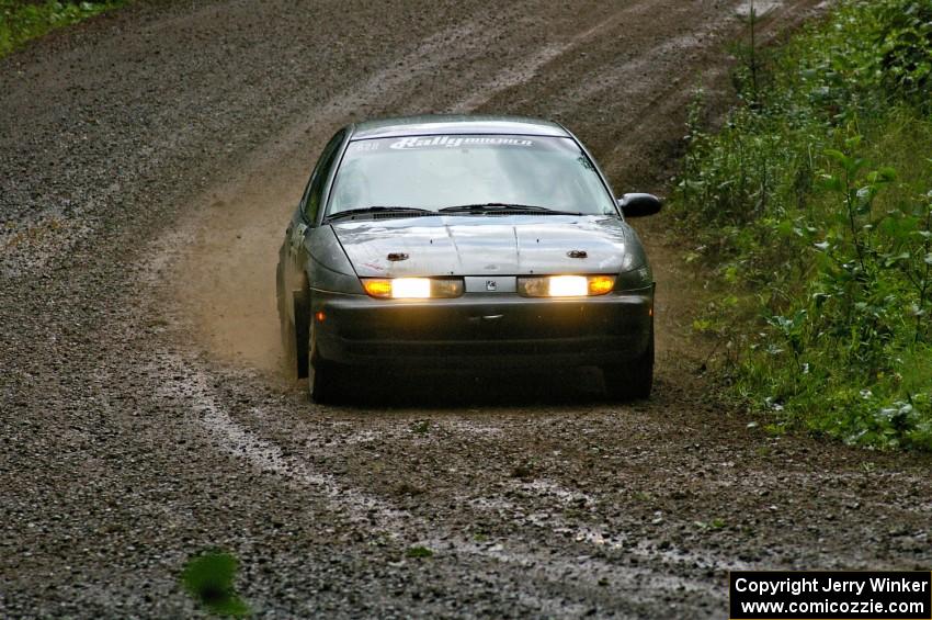 Dan Adamson / Chris Gordon drift their Saturn SL2 through a muddy downhill sweeper on SS5.