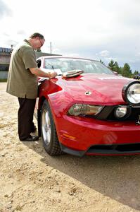 Navigator Rob Bohn reviews notes on the hood of the Ford Mustang driven by Mark Utecht.
