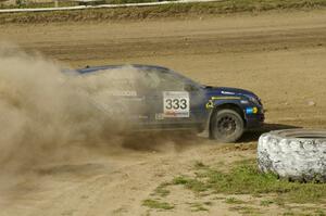 Wyatt Knox / Martin Headland drift their Mazda Speed 3 hard around a tractor tire on SS1.