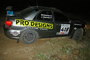 Jimmy Keeney / Missy Keeney power out of a downhill hairpin on SS7 in their Subaru WRX STi.
