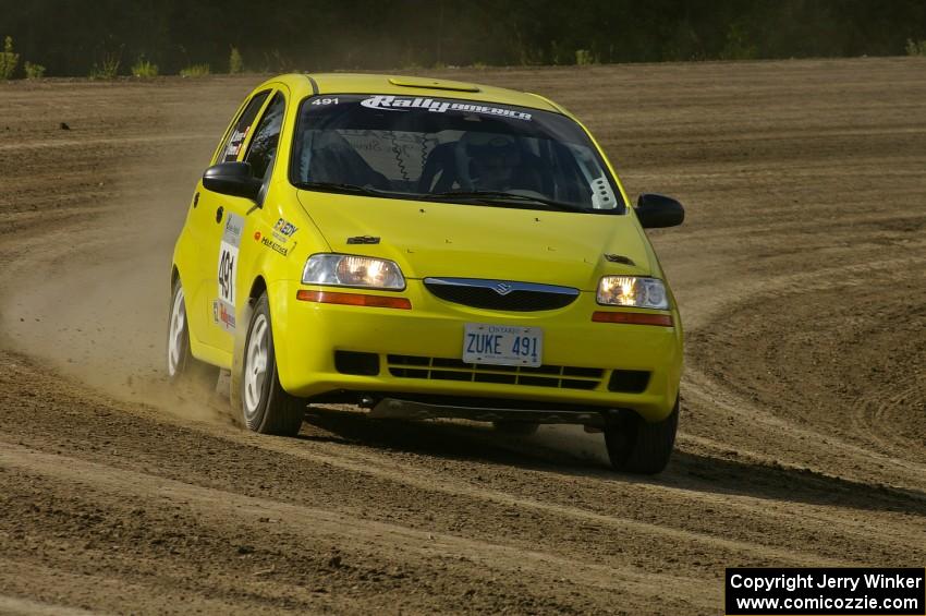 Jim Stevens / Marianne Stevens take their Suzuki Swift along the high bank on SS1.