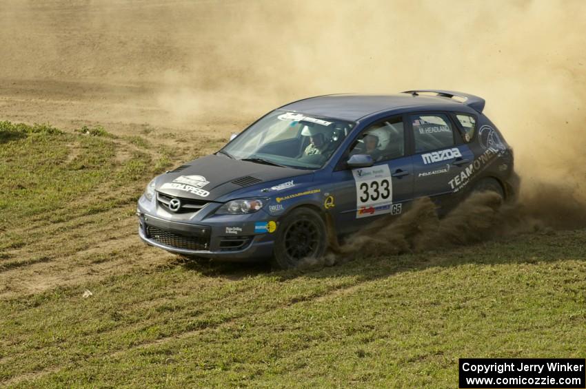 The Wyatt Knox / Martin Headland Mazda Speed 3 throws gravel on the infield section of SS1.