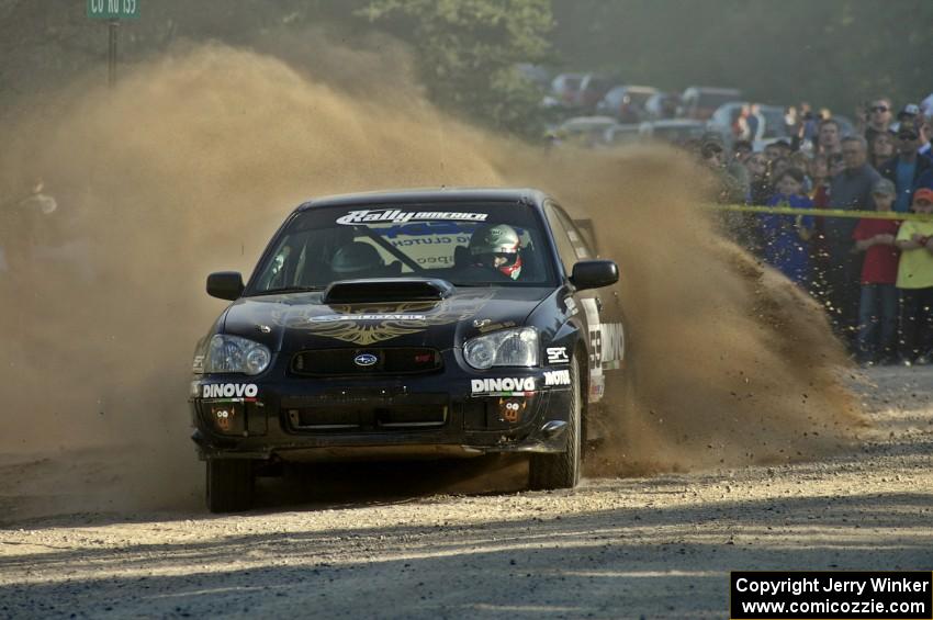 Pat Moro / Jeremy Wimpey spray gravel in their Subaru WRX STi at the spectator location on SS12.