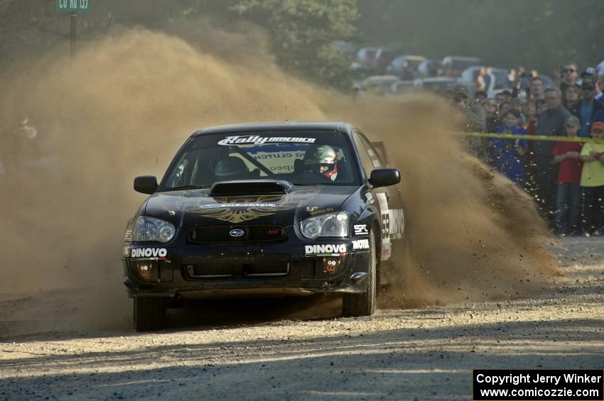 Pat Moro / Jeremy Wimpey spray gravel in their Subaru WRX STi at the spectator location on SS12.