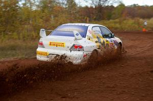 Andi Mancin / Maciej Wislawski drift hard in their Mitsubishi Lancer Evo 9 on a sharp corner on the practice stage.