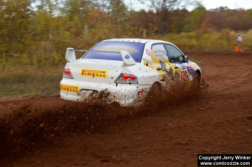 Andi Mancin / Maciej Wislawski drift hard in their Mitsubishi Lancer Evo 9 on a sharp corner on the practice stage.