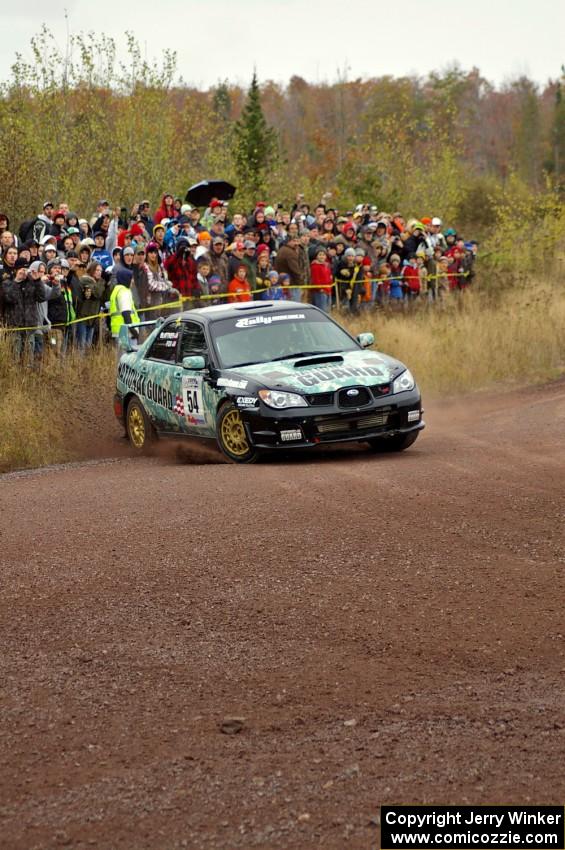 Mark Fox / Jake Blattner spray gravel at the spectator corner on Green Acres, SS1, in their Subaru WRX STi.